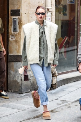 Gigi Hadid wears UGG Tazz slippers and a shearling vest while out and about in Paris on September 29...