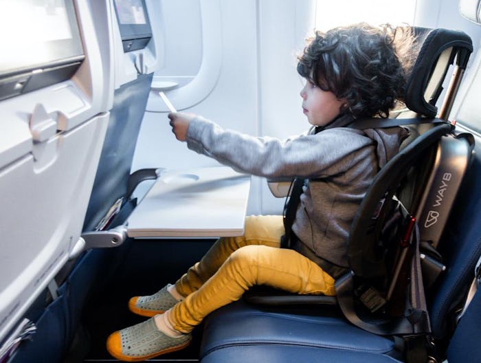 Little kid sitting in Pico car seat installed on an airplane