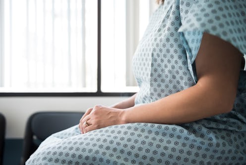 Woman sits in hospital.
