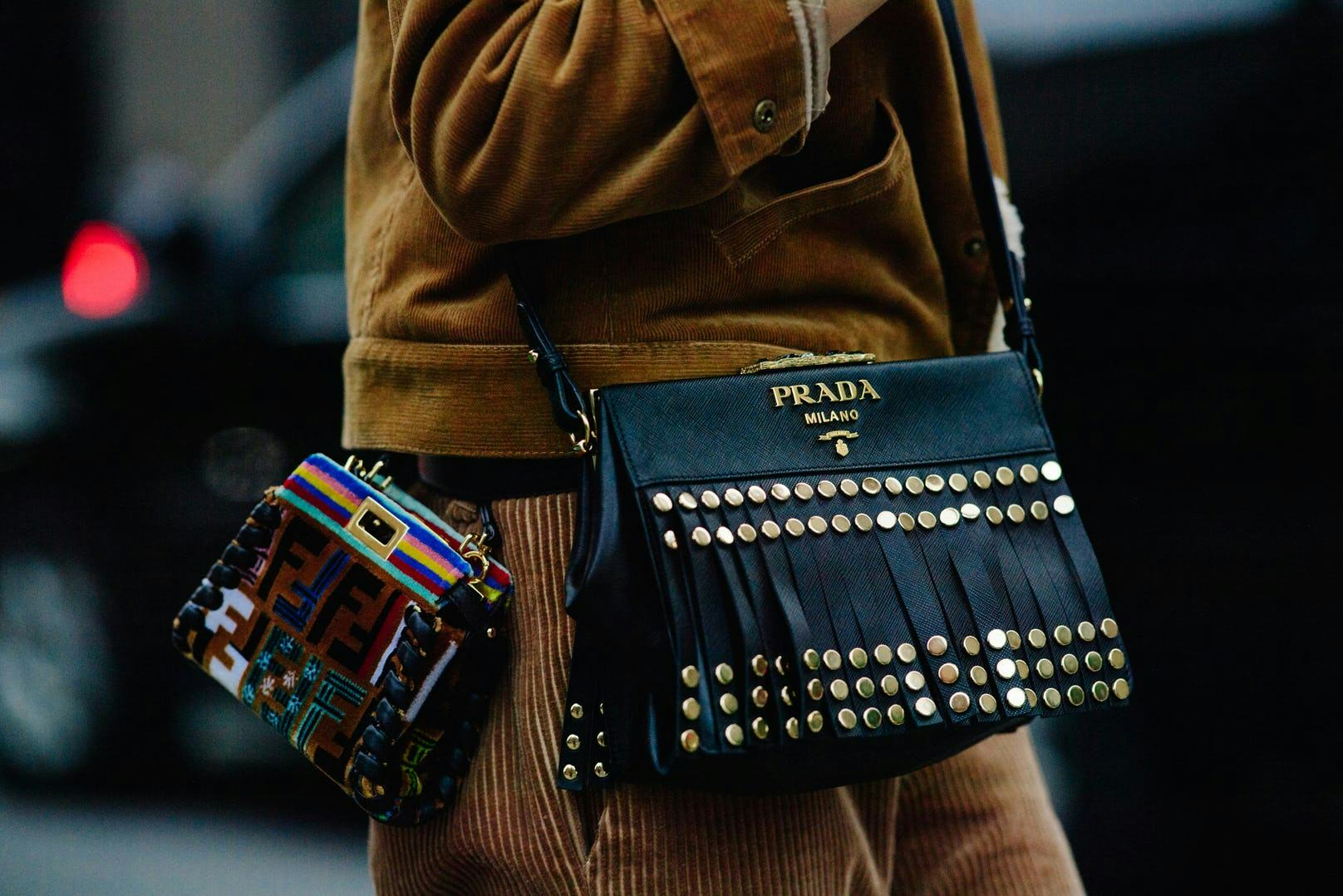 a woman with two designer purses slung over her shoulder