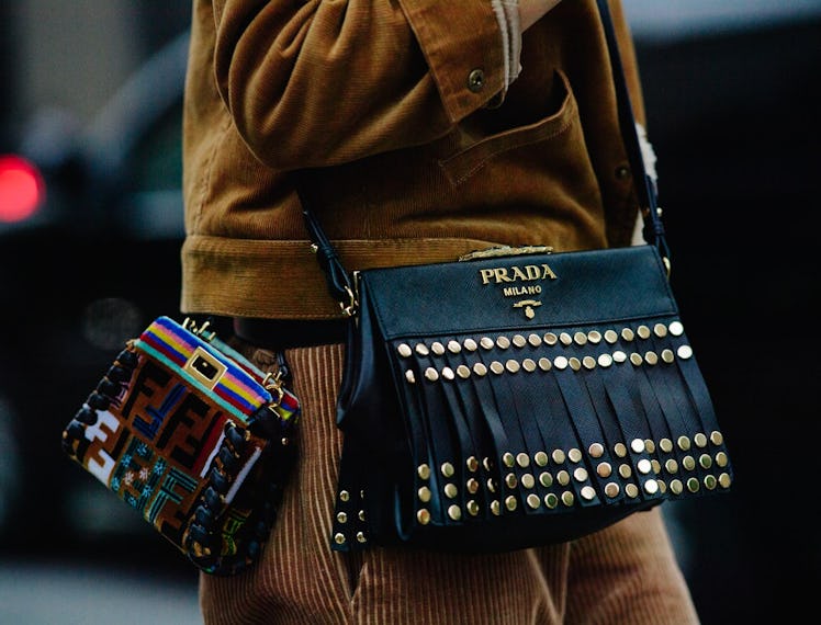 a woman with two designer purses slung over her shoulder