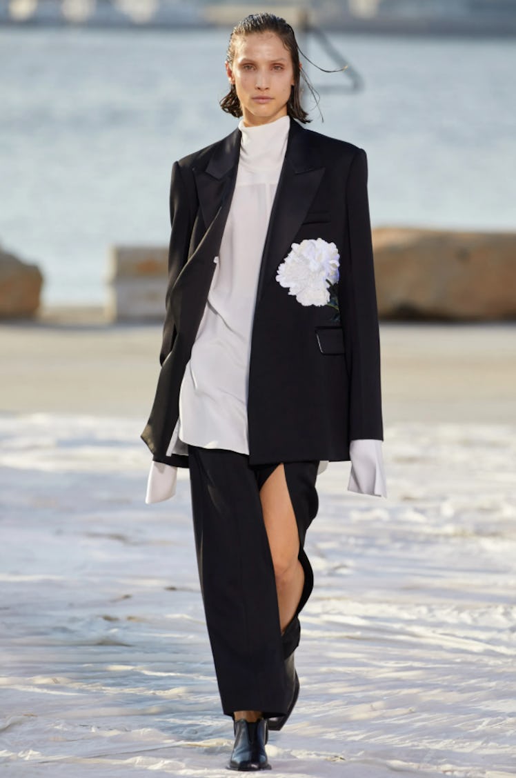 A model wearing a black skirt suit with a white oversized turtleneck by Peter Do during the NYFW Spr...