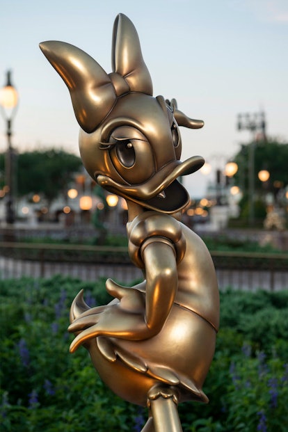 These photos of Disney's gold statues for the 50th-anniversary celebration include Mickey and friend...