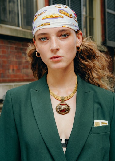 Portrait of girl on the street. Wears green blazer.