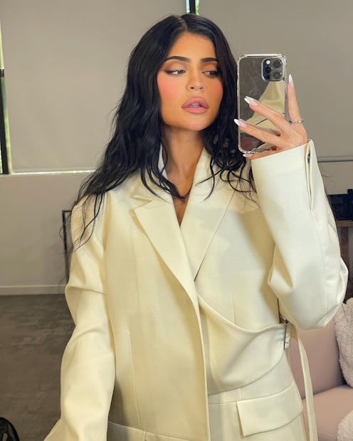 Kylie Jenner poses in a mirror selfie wearing a white blazer.