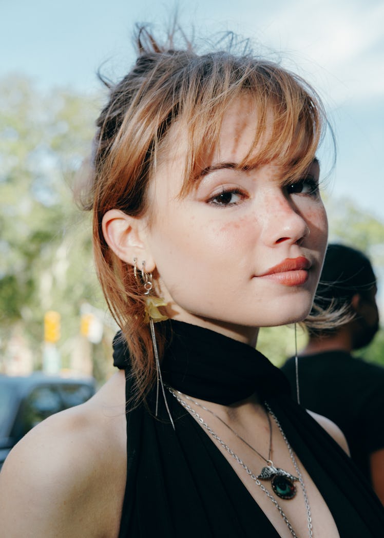 Portrait of girl in black top with necklace.