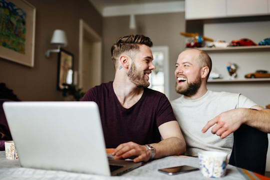 happy couple laughing at funny Valentine's Day memes on a computer