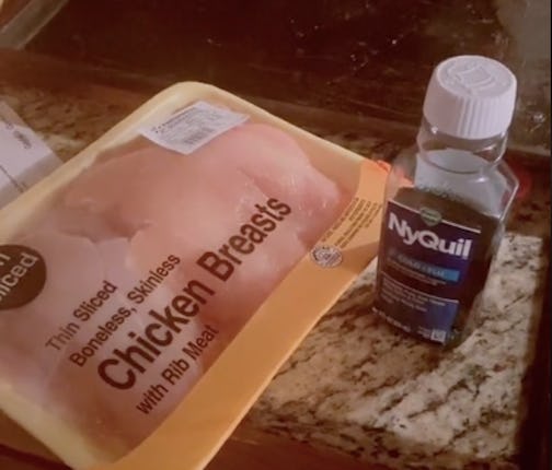 Raw chicken breasts next to a bottle of NyQuil.