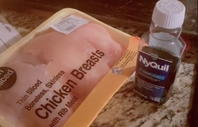Raw chicken breasts next to a bottle of NyQuil.