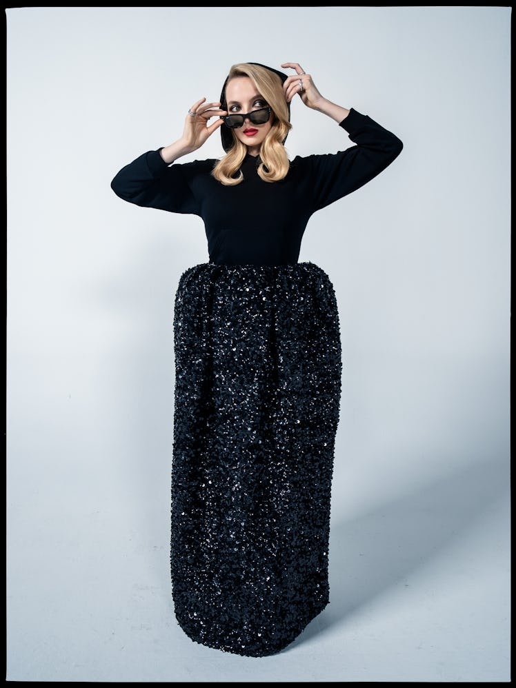 Jodie Comer wears a Balenciaga hoodie and skirt; Ray-Ban sunglasses; Bulgari rings.