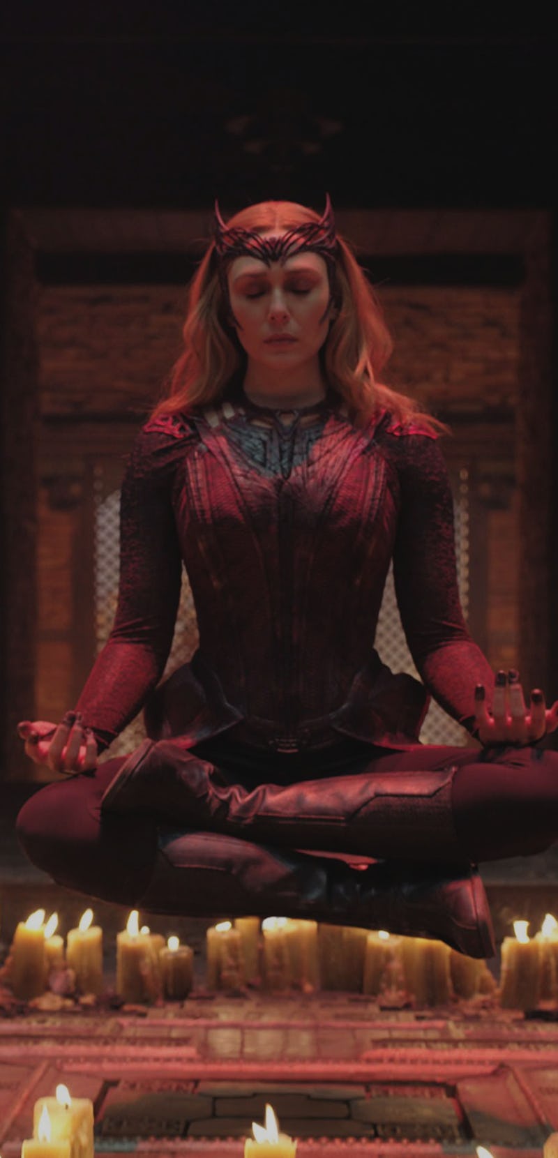 Elizabeth Olsen meditating surrounded by candles as Scarlet Witch