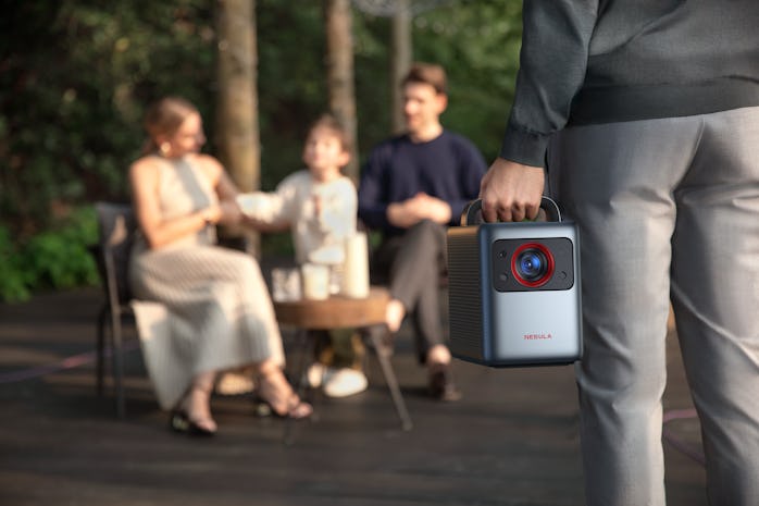 Family using Anker Nebula's Cosmos Laser 4K outdoors.