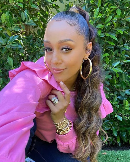 Tia Mowry pink blouse long ponytail