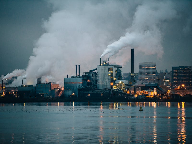 An industrial plant spews smoke at night