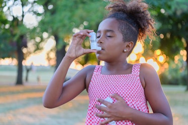 Black child using an inhaler to deal with asthma