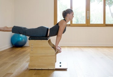 a woman posing on a pilates alignment tower