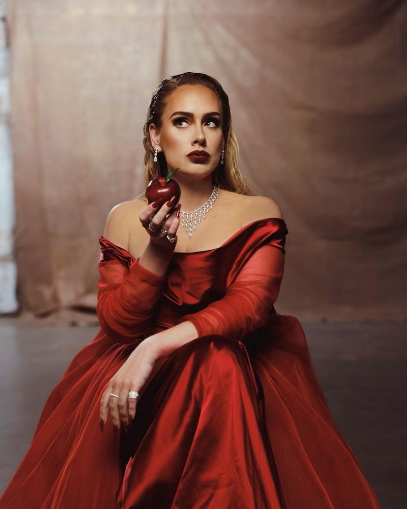 Adele holding up an apple