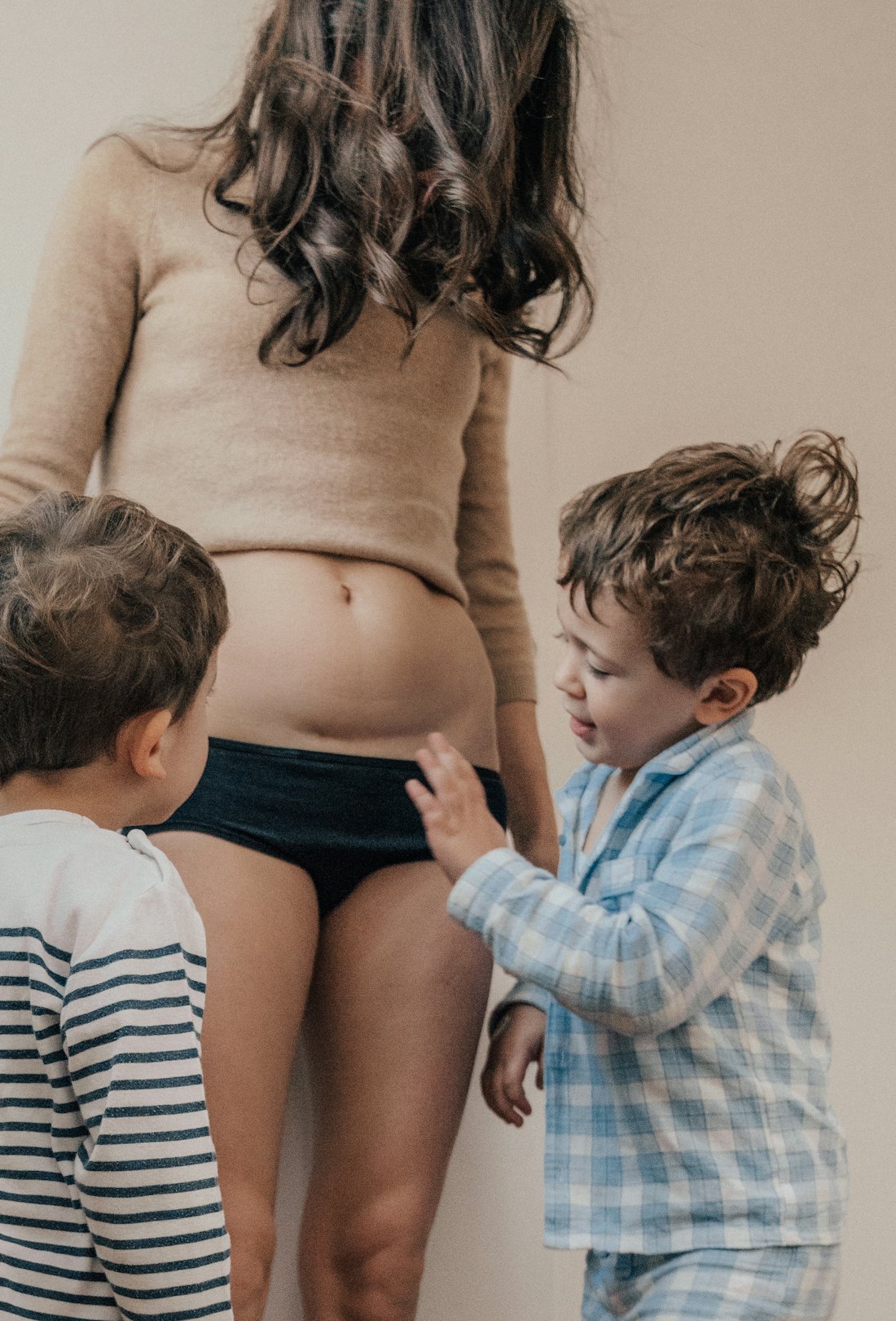 Two children checking their mom's stomach in her C-section recovery time