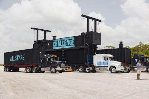 A photo of two semi trucks with black cargo that has blue writing on the side. One truck says "chal...