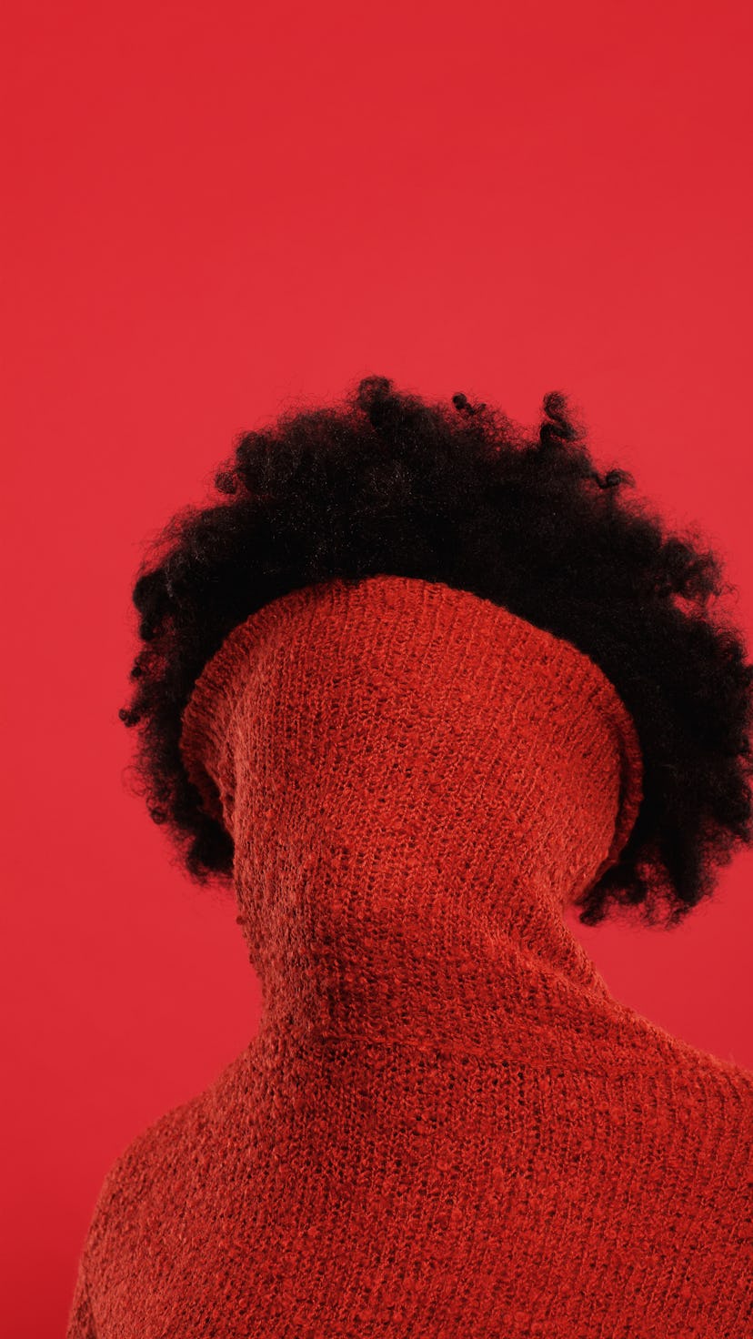 Young woman with her turtleneck sweater covering her face as Uranus retrograde ends on Jan. 18, 2022...