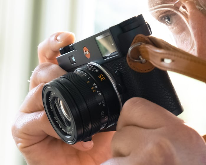 Man looking through viewfinder of Leica M11