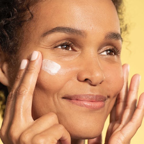 A woman applying the high-tech Contour Restore Tightening & Sculpting Face Cream moisturizer 