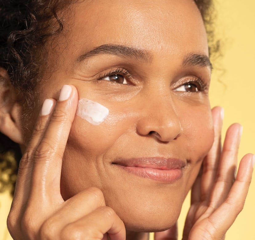 A woman applying the high-tech Contour Restore Tightening & Sculpting Face Cream moisturizer