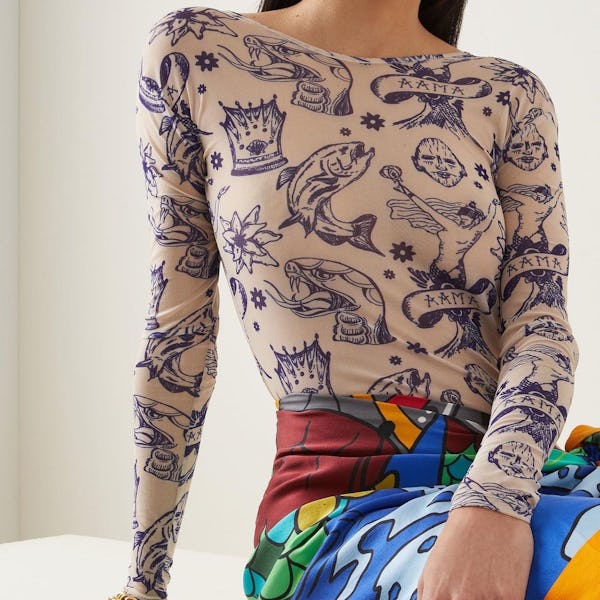 A model sitting, wearing a printed mesh top and skirt by House of Aama