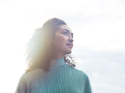 Young woman looking toward the full moon the week of January 17, 2022, which will be the best for he...