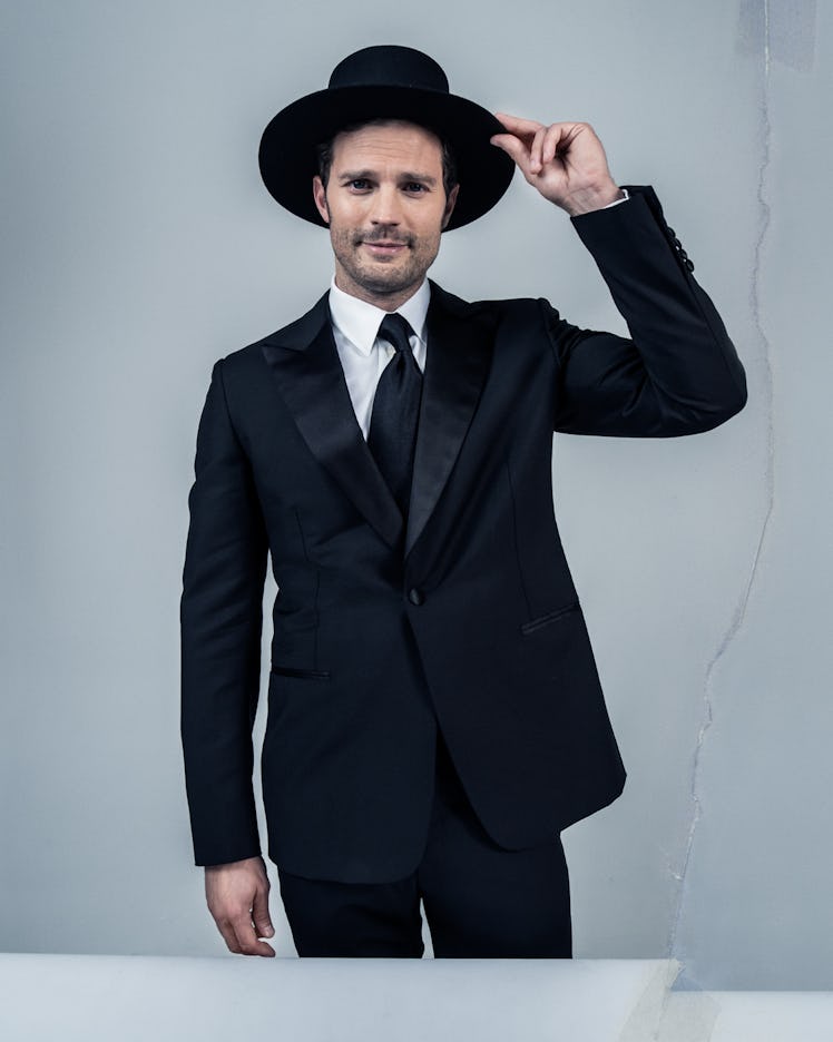Jamie Dornan wears an Hermès tuxedo, shirt, and tie; Saint Laurent by Anthony Vaccarello hat.