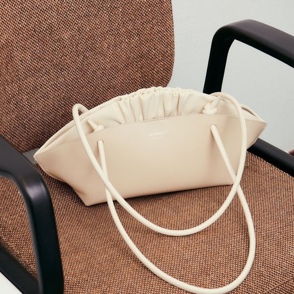 A sculptural ivory handbag with ruffles on a chair, by Ree Projects