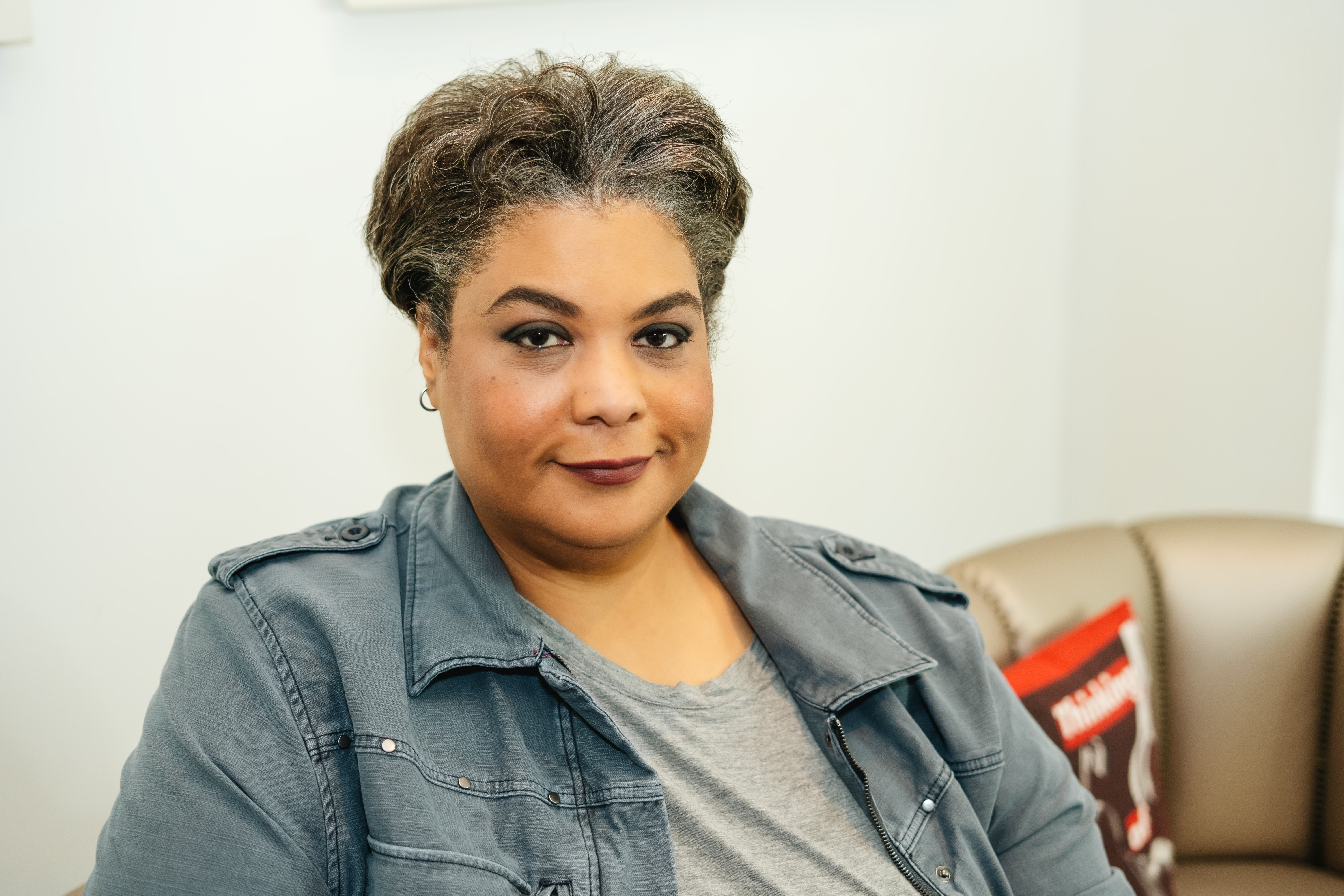 Roxane Gay in a grey denim jacket and a grey t-shirt 