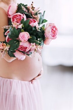 pregnant woman holding a bouquet of flowers