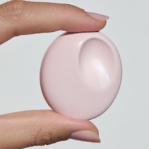 A woman holding the Glossier You Solid Perfume Casing