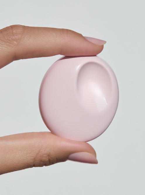 A woman holding the Glossier You Solid Perfume Casing