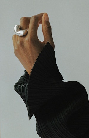 A hand model wearing a chunky silver ring by Agmes x Simone Bodmer-Turner
