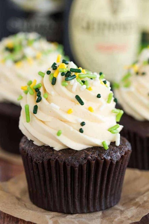 chocolate cupcakes with white frosting and green sprinkles