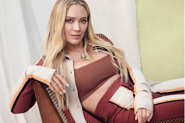 Hillary Duff posing in a burgundy Tod’s coat, pants and Calle del Mar bandeau