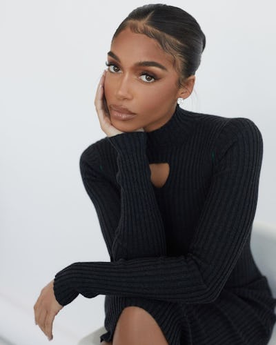 Lori Harvey posing while wearing her iconic '90s haircut and a black bodycon dress
