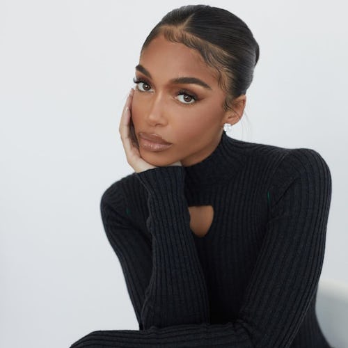 Lori Harvey posing while wearing her iconic '90s haircut and a black bodycon dress