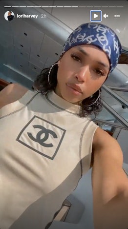 Lori Harvey posing for her Instagram Story while wearing a blue bandana and Chanel top