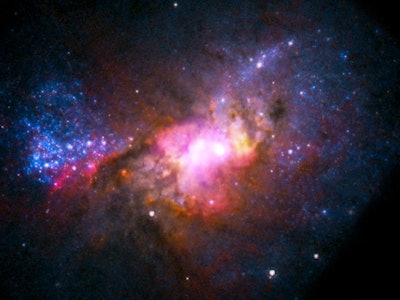 A composite picture shows radio and x-ray emissions from the dwarf galaxy Henize 2-10