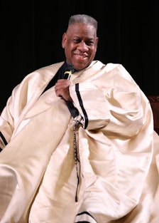 Andre Leon Talley on stage in an extravagant white cape. 