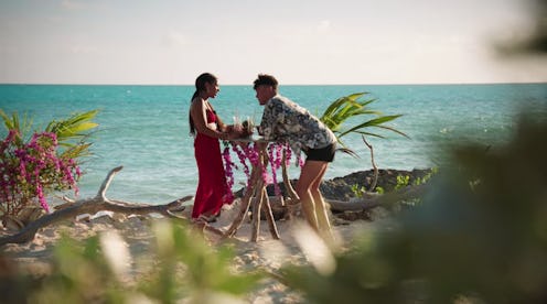 'Too Hot To Handle' Season 3 contestants Izzy and Jackson standing at a tall table in front of a blu...