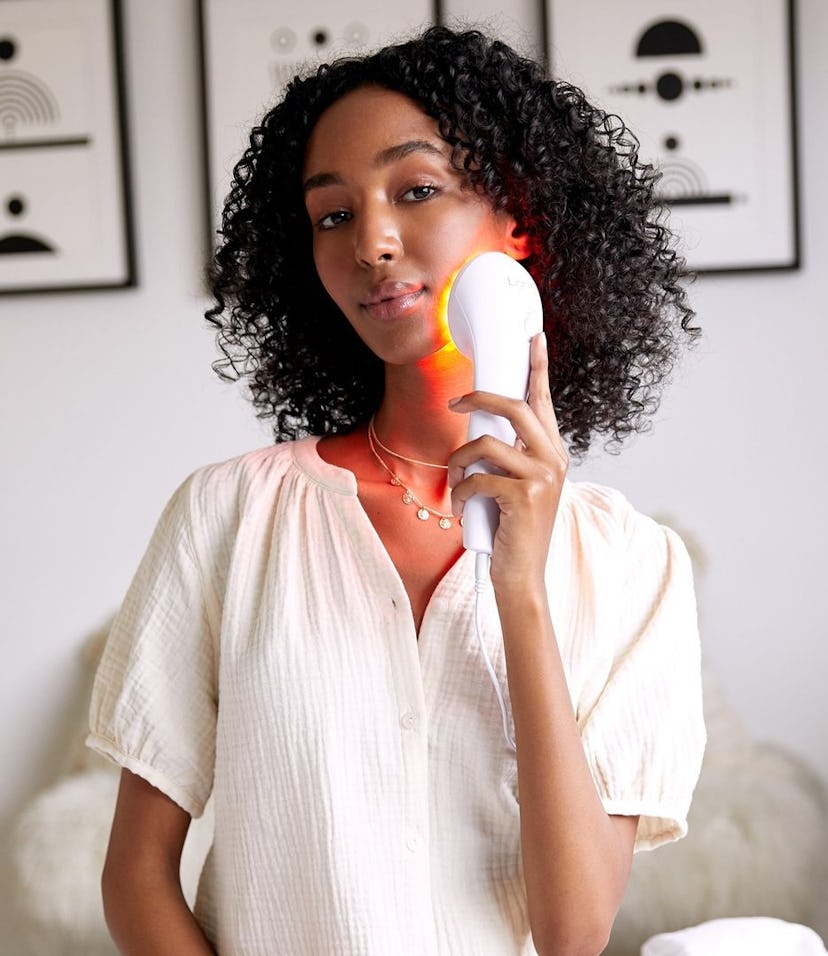 Curly-haired deep skin tone model with Lightstim high-frequency device
