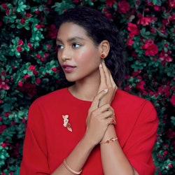 A model wearing red and gold jewelry. 