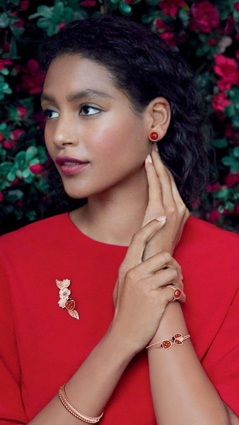 A model wearing red and gold jewelry.