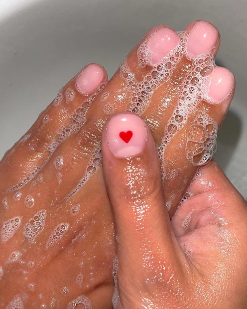 A woman washing her hands during her hand care routine that saves her from brittle nails & dry skin