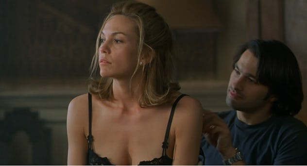 Connie looks in the distance as her lover, Paul, sits behind her