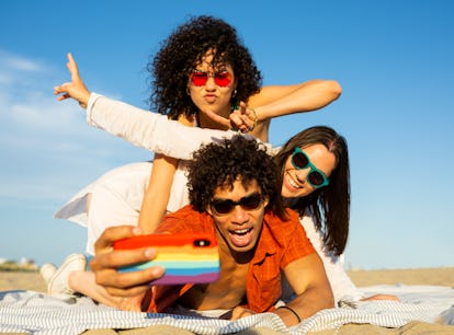 Group of friends taking a selfie on the beach after applying to Marriot Bonvoy's TikTok corresponden...